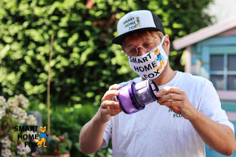 Filter des Akkustaubsaugers im Freien, über der Tonne reinigen